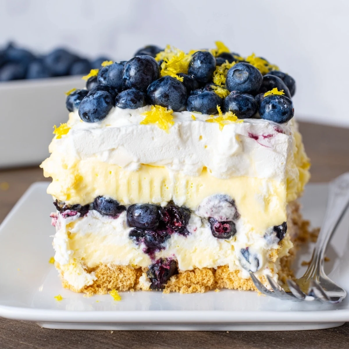 A vibrant slice of No-Bake Lemon Blueberry Cream Cake garnished with fresh blueberries.  
