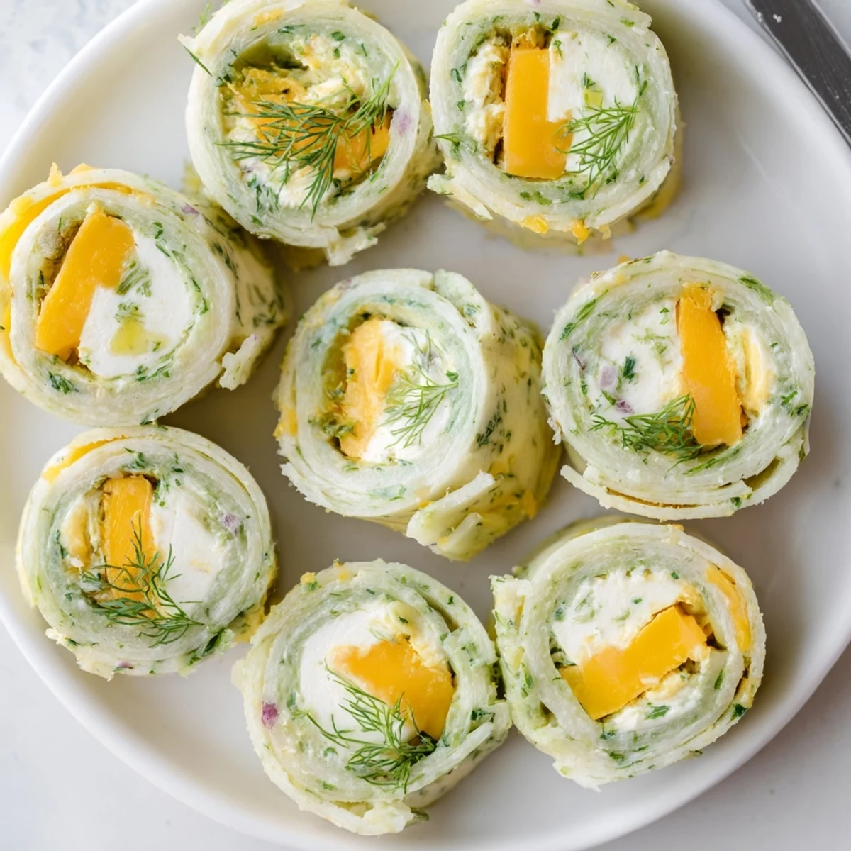 Crisp dill pickles wrapped in cheese-filled tortillas make perfect pickle-in-a-blanket snacks.  
