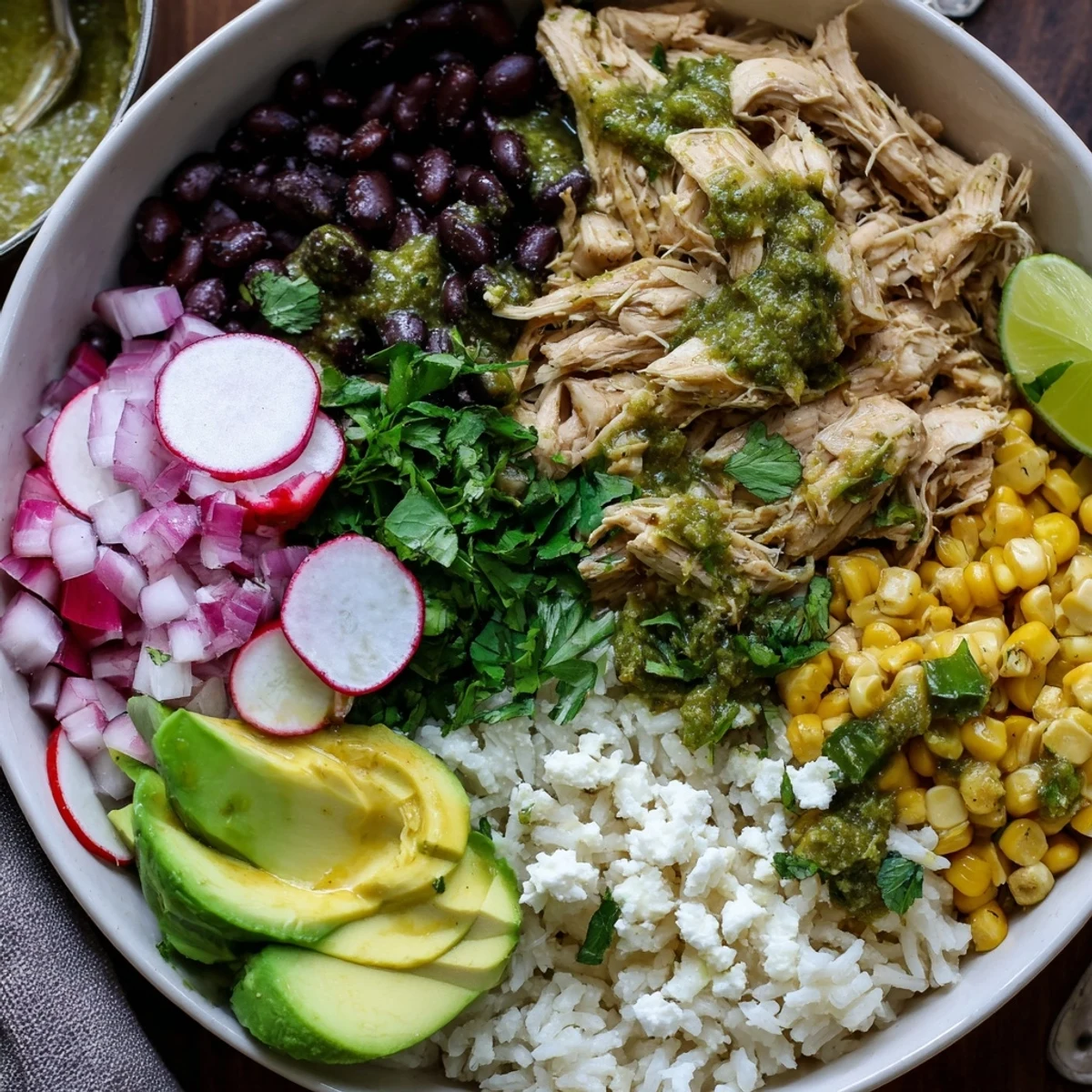 A colorful Green Enchiladas Rice Bowl topped with avocado, beans, and cheese.  