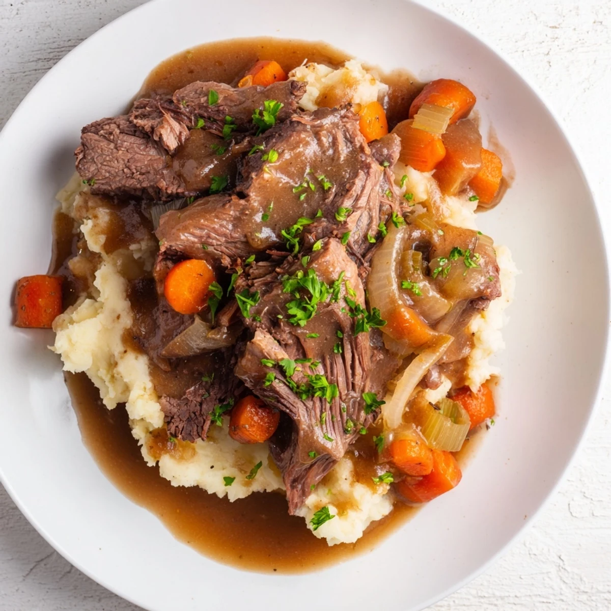Hearty American dinner: Delicious Slow Cooker Pot Roast with carrots and celery, served with mashed potatoes.