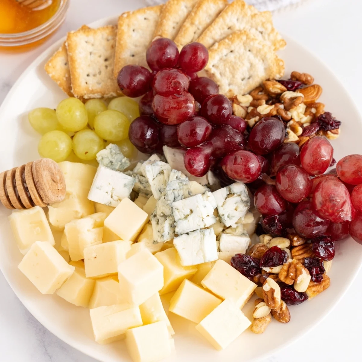 A close-up of the Cranberry Grape Man cheese board, offering a delightful appetizer of cheeses, fruit, and crackers.