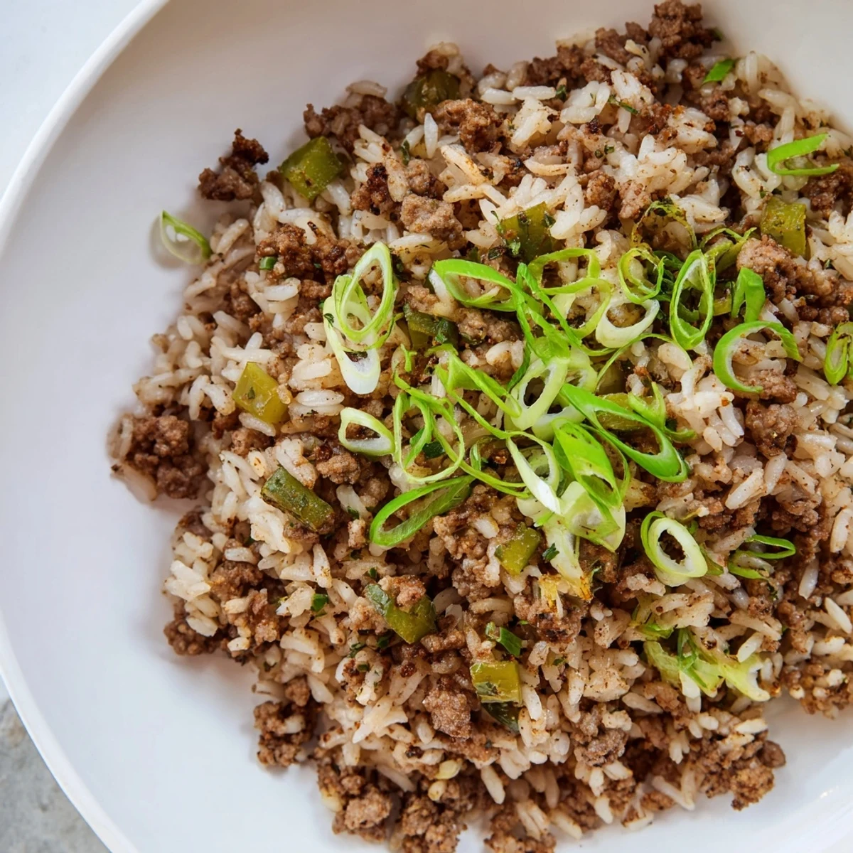 Steaming Cajun Dirty Rice, a flavorful Southern main dish, ready to serve with fresh green onions.