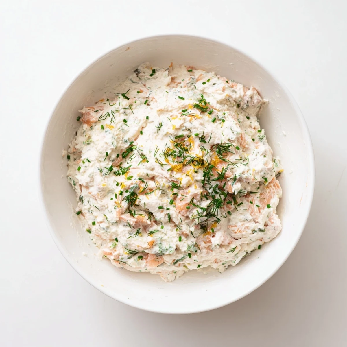 Smooth smoked salmon dip spread on a crispy bagel chip, topped with extra herbs and a hint of lemon zest.  