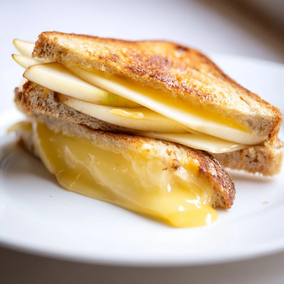 A gourmet Smoked Gouda & Apple Grilled Cheese sandwich, oozing creamy cheese and buttery, toasted bread.  