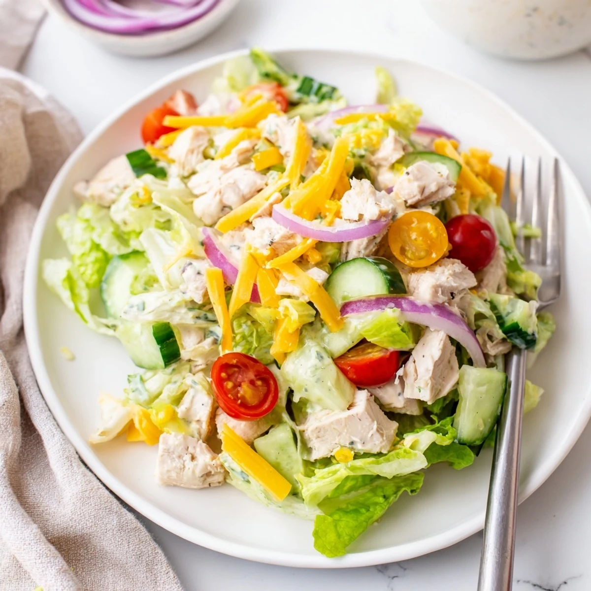 This spicy Jalapeño Ranch Chicken Salad is garnished with red onion and cucumber slices, ready for a refreshing meal.