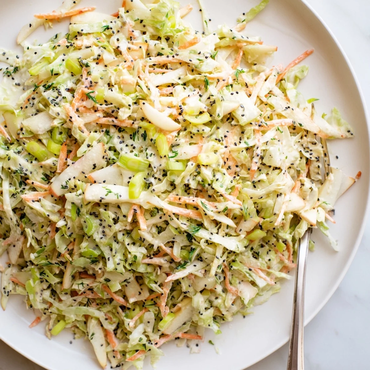 Bright, crisp shreds of green cabbage and tart Granny Smith apples tossed in a tangy apple cider vinegar dressing.  