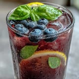Refreshing blueberry lemon basil lemonade garnished with fresh basil and berries.