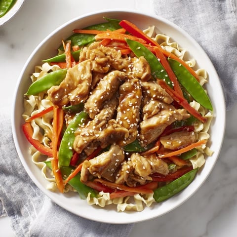 Steaming hot Lemon-Garlic Chicken Stir Fry with noodles, a colorful mix of chicken and veggies.
