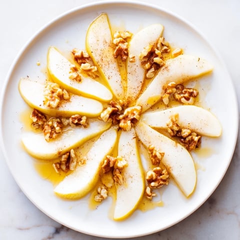Fresh, juicy pear slices with a golden honey drizzle, making a simple yet elegant dessert.