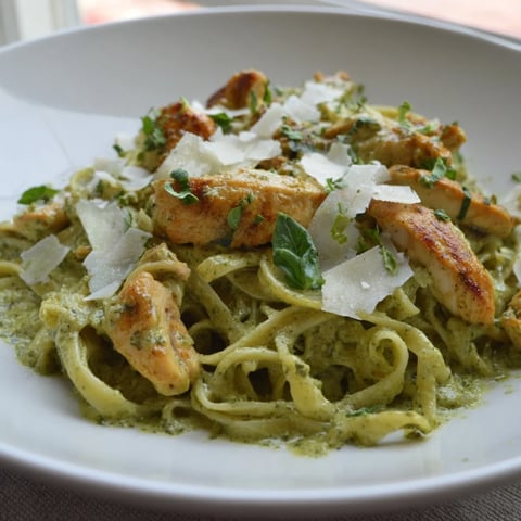 Golden chicken and pesto egg pasta: a flavorful, creamy meal topped with fresh basil and Parmesan.
