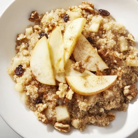 Steaming Apple Cinnamon Quinoa Bowl, a cozy breakfast with warm apples and cinnamon spice aroma.