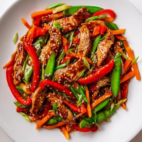 Sweet Teriyaki Pork Stir-Fry: a steaming bowl featuring glistening pork and vibrant, crisp vegetables like peppers.
