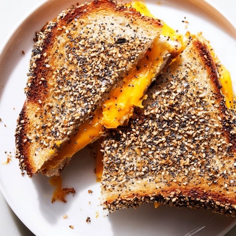 Golden-brown Everything Bagel Grilled Cheese oozes melted cheese, a savory and satisfying vegetarian dish.