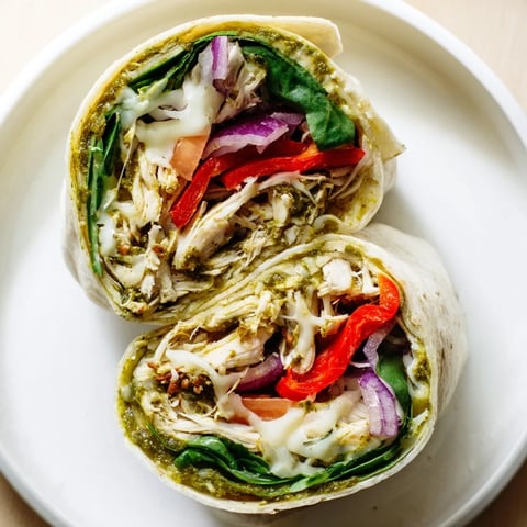 A close-up of a delicious Pesto Chicken Wrap, filled with vibrant ingredients and ready to eat.