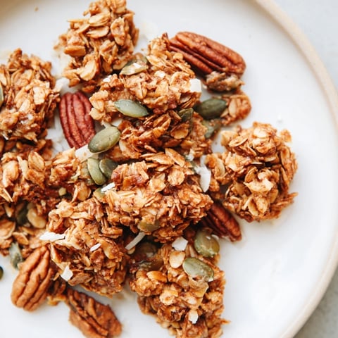 Golden-baked homemade granola clusters with toasted oats, nuts, and honey on a rustic tray for breakfast.