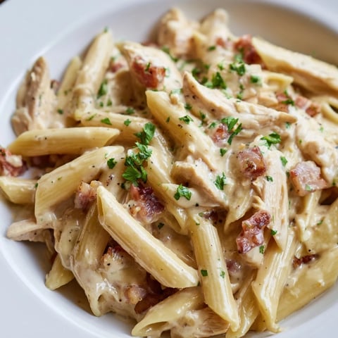 Creamy Chicken Bacon Penne pasta served in a white bowl, topped with fresh parsley and extra Parmesan for a cozy weeknight meal.