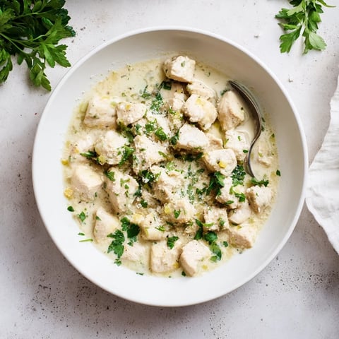 Tender Creamy Garlic Chicken Bites simmering in a glossy, rich sauce in a skillet, garnished with fresh parsley.  