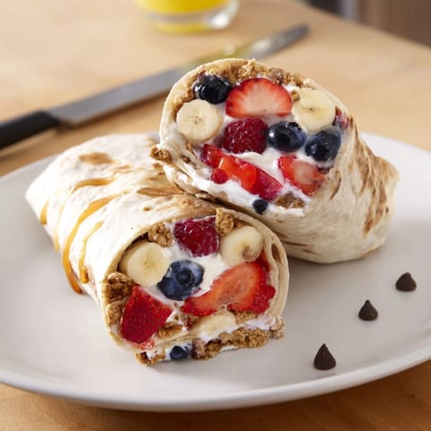 Creamy yogurt, fresh berries, and crunchy cereal burst from warm Cinnamon Toast Crunch Breakfast Wraps.