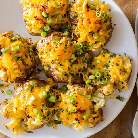 Delicious golden potato bombs garnished with green onions, ideal for dipping.  