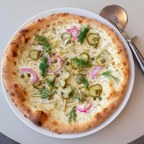 Deliciously unique pickle pizza with a golden crust and fresh dill garnish.  