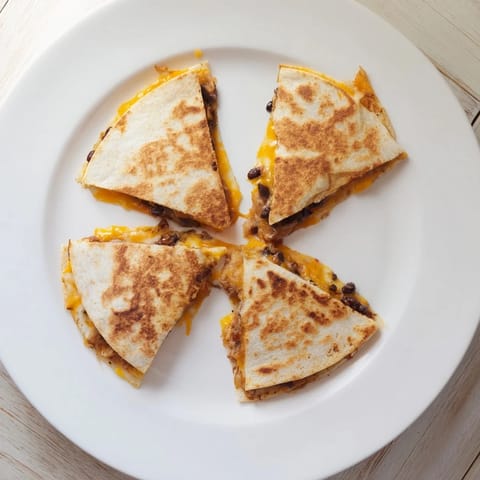 A close-up of cheesy bean and cheese quesadillas, with a side of fresh salsa for dipping.