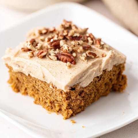 Close-up shot shows frosted Pumpkin Bars with inviting, soft brown sugar swirls.