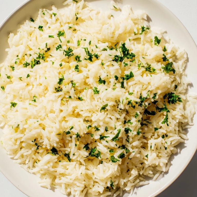 A close-up of fragrant garlic butter rice, featuring tender grains with glistening, savory butter.